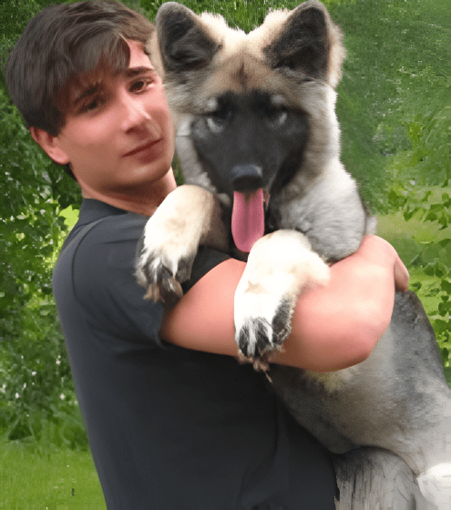 A man holding a dog in his arms.