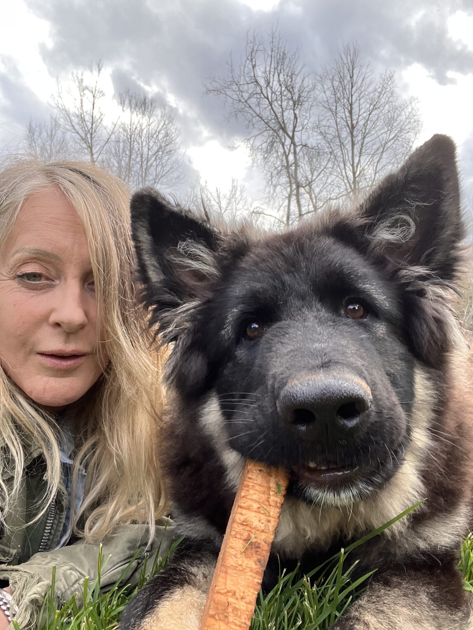 A woman and her dog are eating some food.