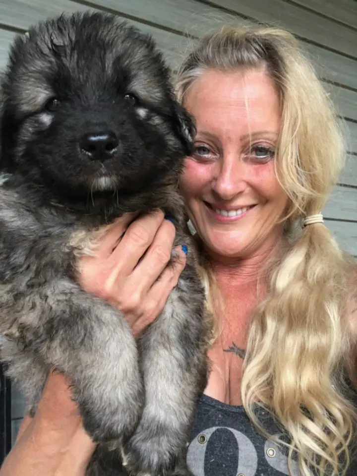 A woman holding a dog in her arms.