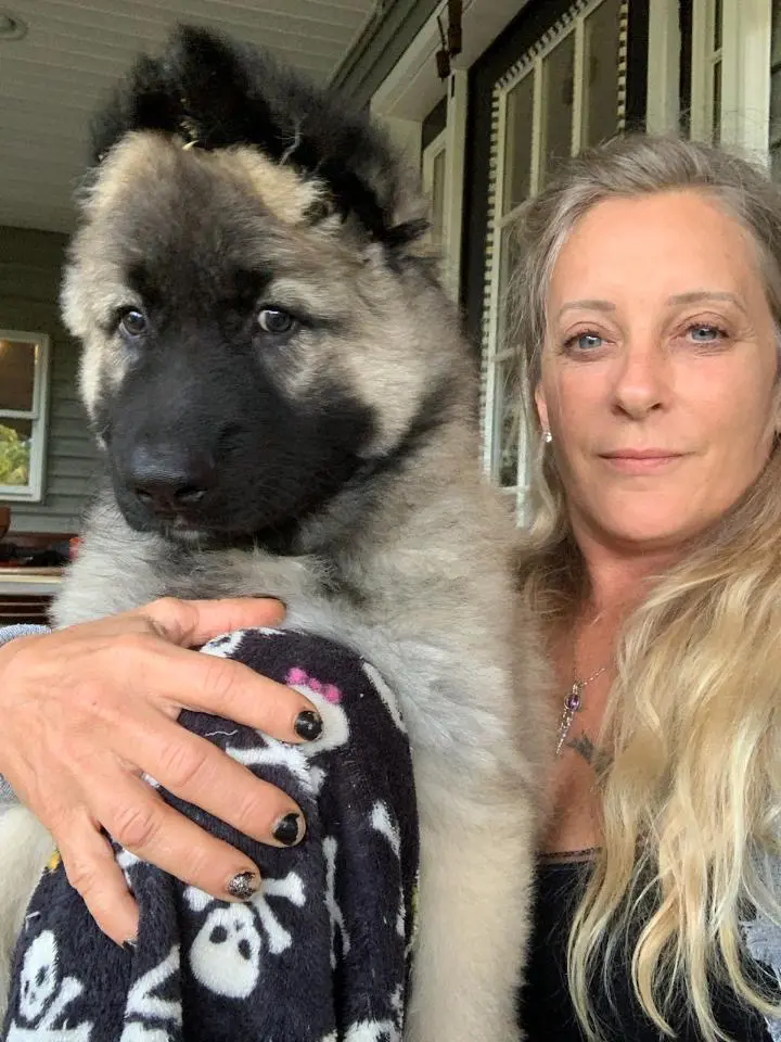 A woman holding a dog in her arms.