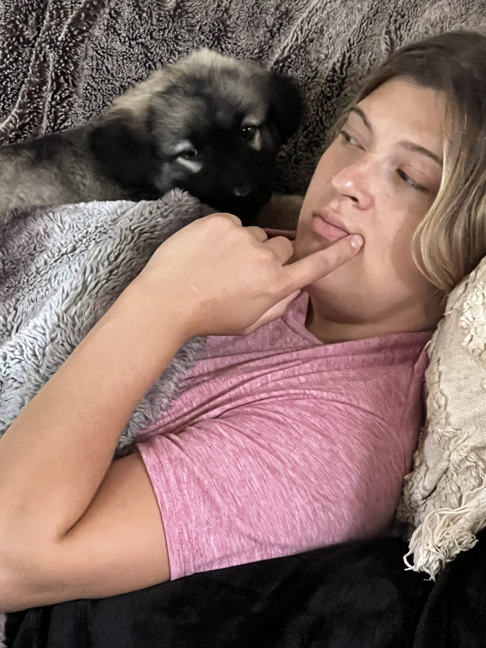 A woman laying in bed with her cat.